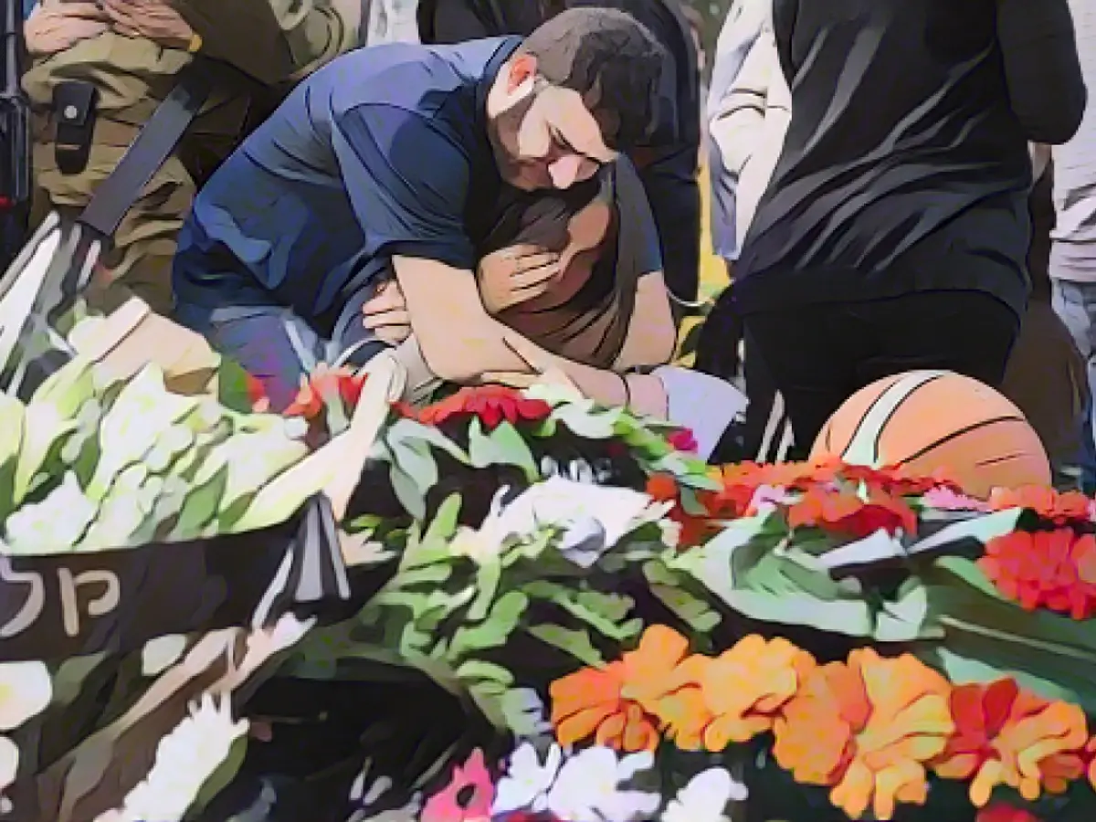 Родственники и друзья скорбят, собираясь на похороны Алона Шамриза, ошибочно убитого израильскими войсками в Газе в начале недели после того, как его удерживал ХАМАС с момента нападения 7 октября, в кибуце Шефаим недалеко от Тель-Авива 17 декабря 2023 года.