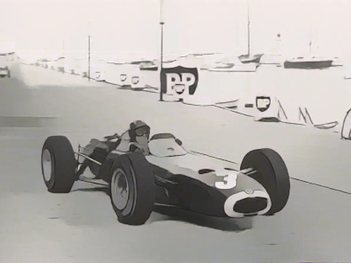 За 18-летнюю карьеру в Формуле-1 Грэм Хилл пять раз побеждал в Монако. Здесь он участвует в гонке во время Гран-при 1965 года, где он в третий раз стал чемпионом, несмотря на то, что ему пришлось вернуть машину на трассу и перезапустить ее после того, как он избежал столкновения с трассой.