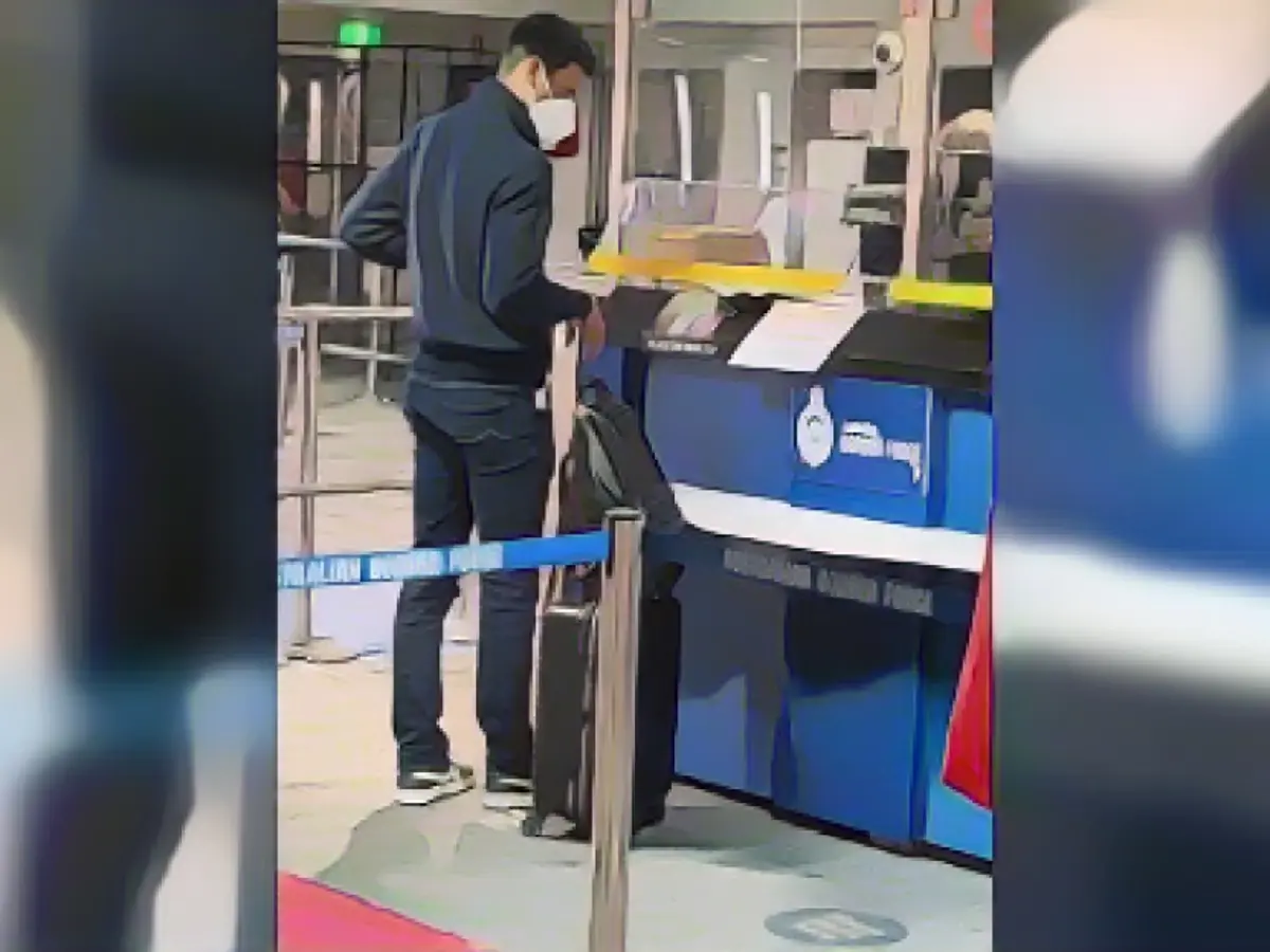 Djokovic si trova davanti a uno stand dell'Australian Border Force a Melbourne mercoledì.