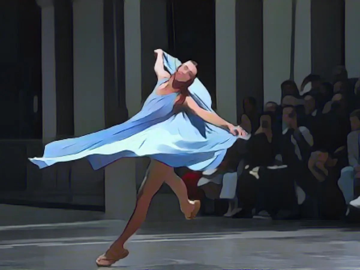 Модель танцует, представляя творение для Issey Miyake.