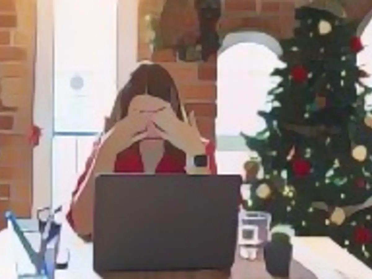 Красивая женщина сидит за столом и работает с ноутбуком дома вокруг рождественской елки, потирая глаза от усталости и головной боли, с сонным и усталым выражением лица. Проблема со зрением