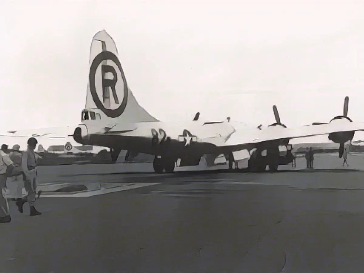 Самолет B-29 Superfortress Enola Gay пролетает над бомбовой ямой на Северном поле авиабазы Тиниан, Северные Марианские острова, начало августа 1945 года. Самолет был загружен атомной бомбой под кодовым названием Little Boy, которую он сбросил на японский город Хиросима 6 августа.