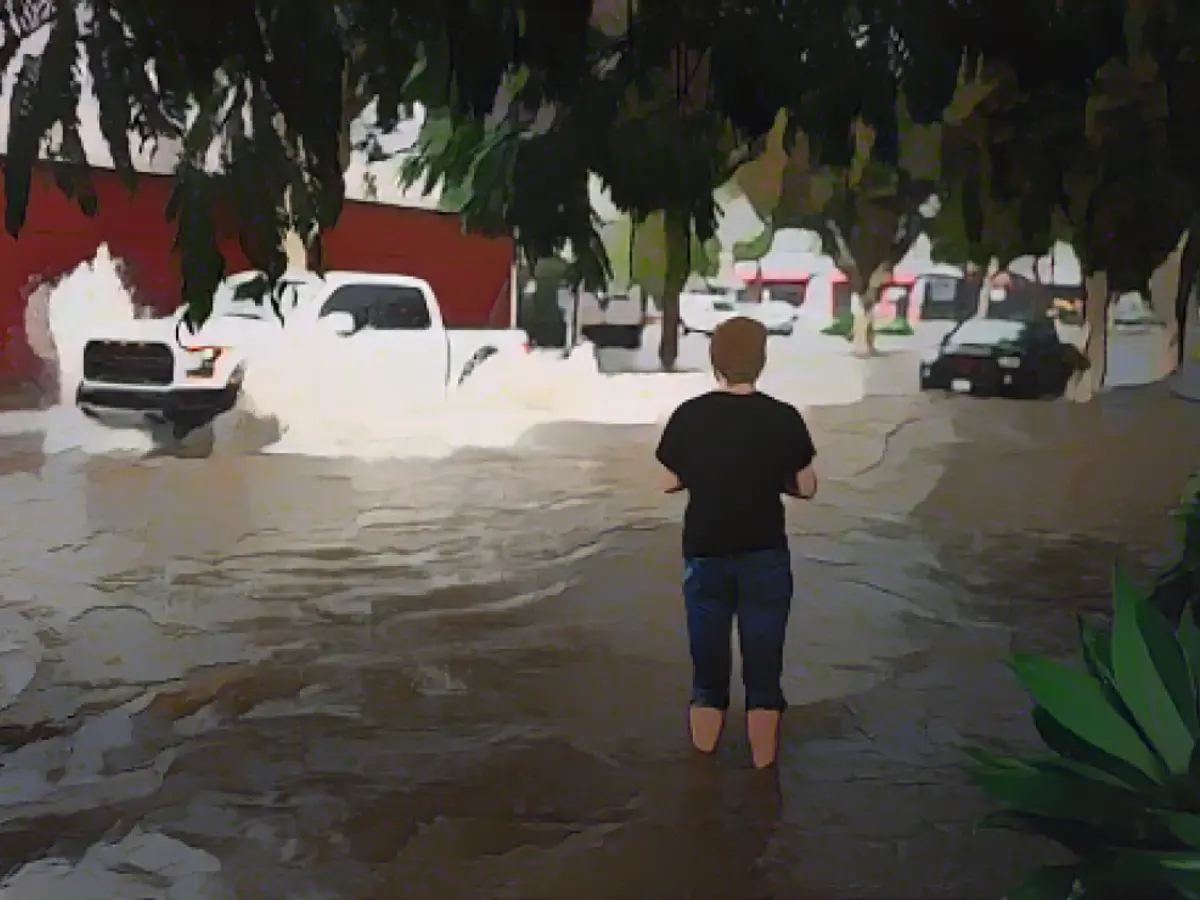 Um homem observa os automobilistas a passarem por uma rua inundada durante uma tempestade de chuva na quinta-feira em Santa Barbara, Califórnia.