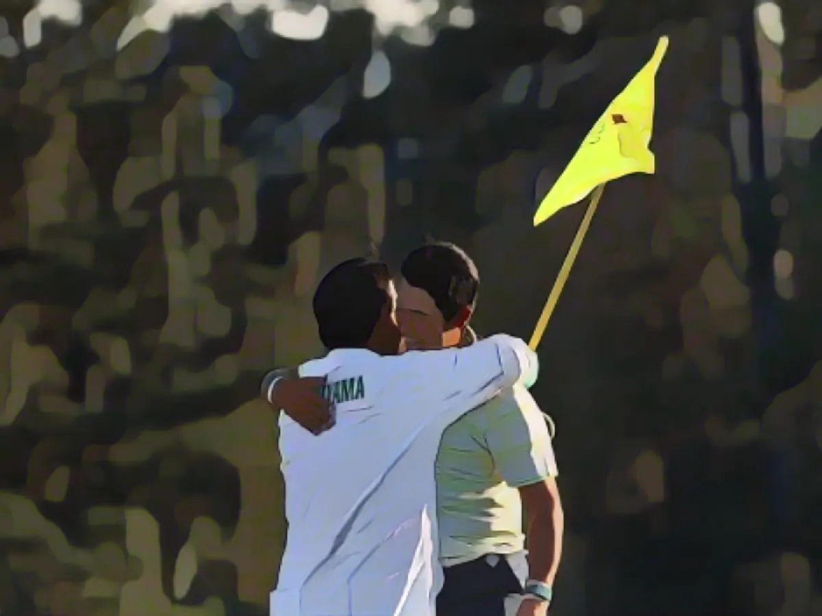 Matsuyama festeja com o seu caddie, Shota Hayafuji, no green do 18º buraco, no domingo.