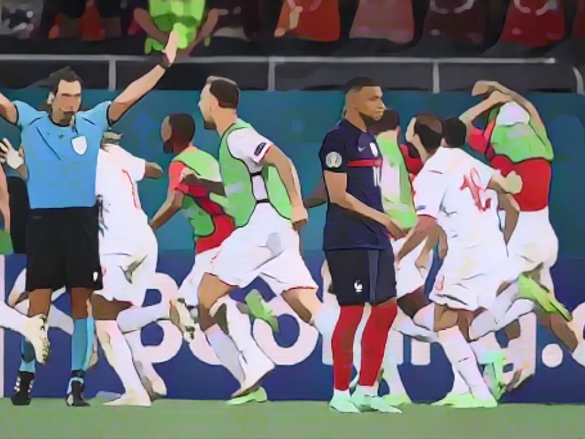 Игроки сборной Швейцарии празднуют после того, как Килиан Мбаппе пробивает решающий пенальти.