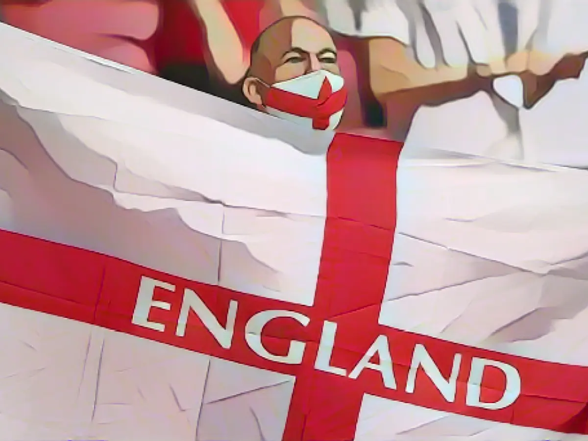 Болельщик сборной Англии размахивает флагом перед началом матча Евро-2020 между сборными Англии и Германии.