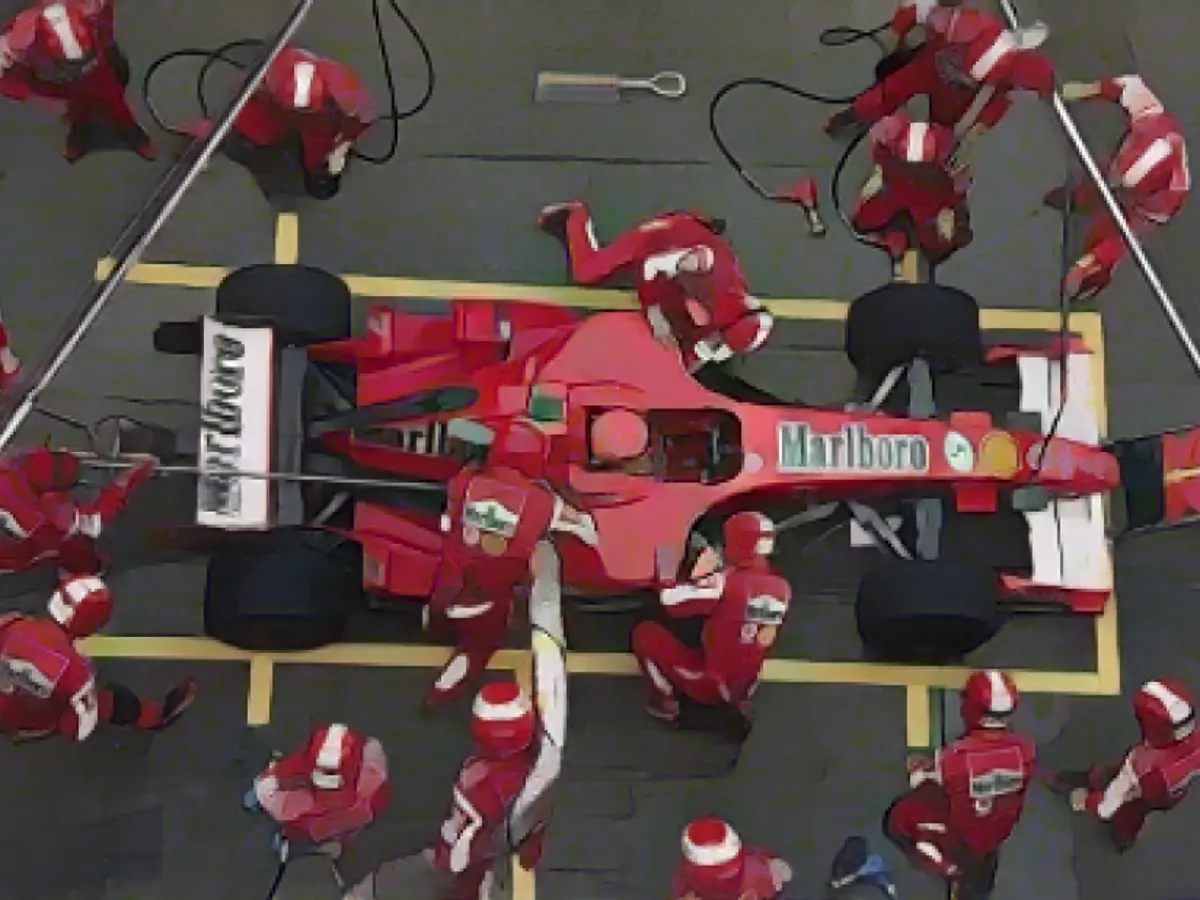 A equipa das boxes de Schumacher trabalha no seu carro durante o Grande Prémio da China de Fórmula 1 em Xangai, em 2006.