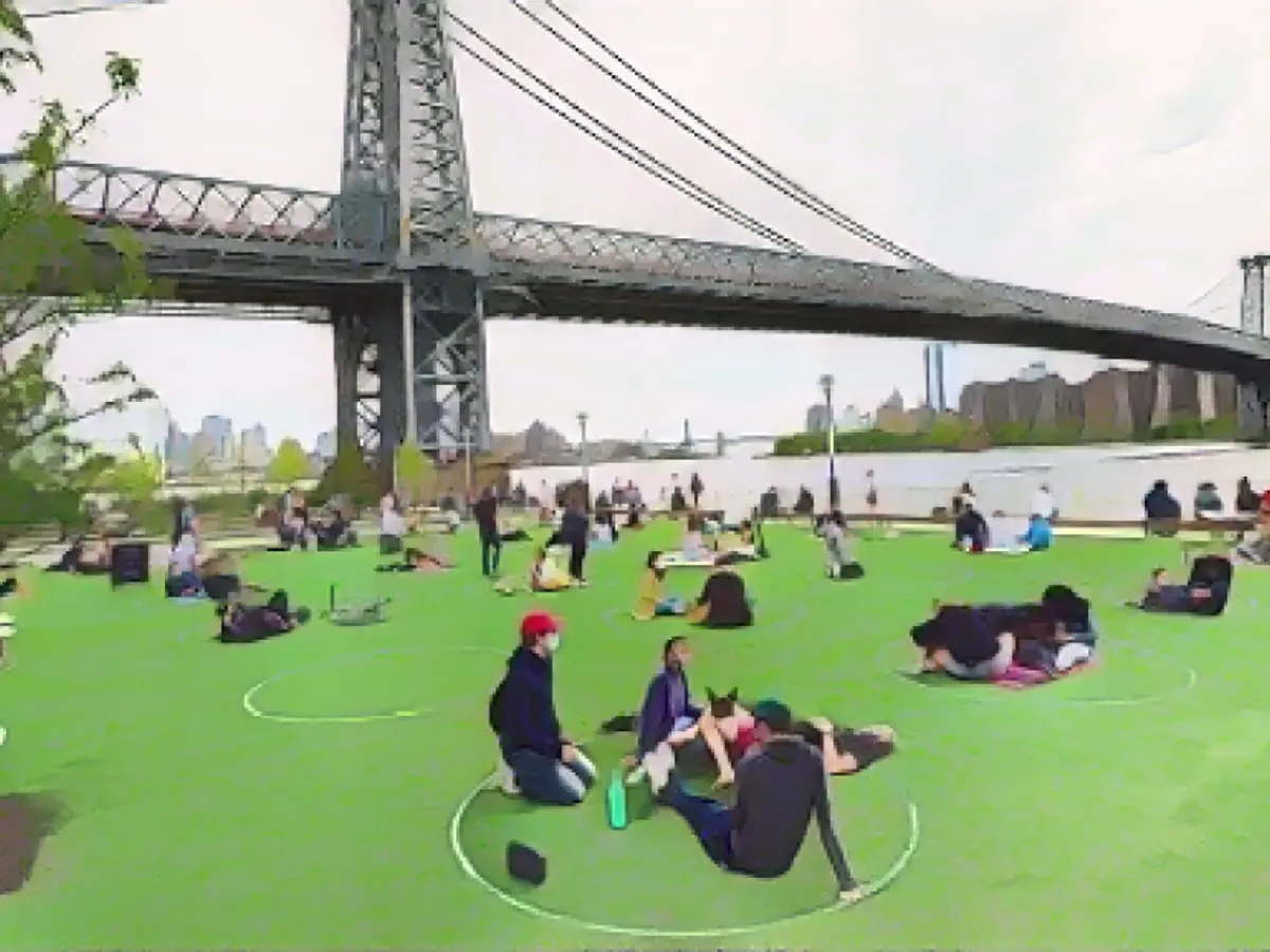 As pessoas praticam o distanciamento social no Domino Park, em Williamsburg, durante a pandemia do coronavírus.