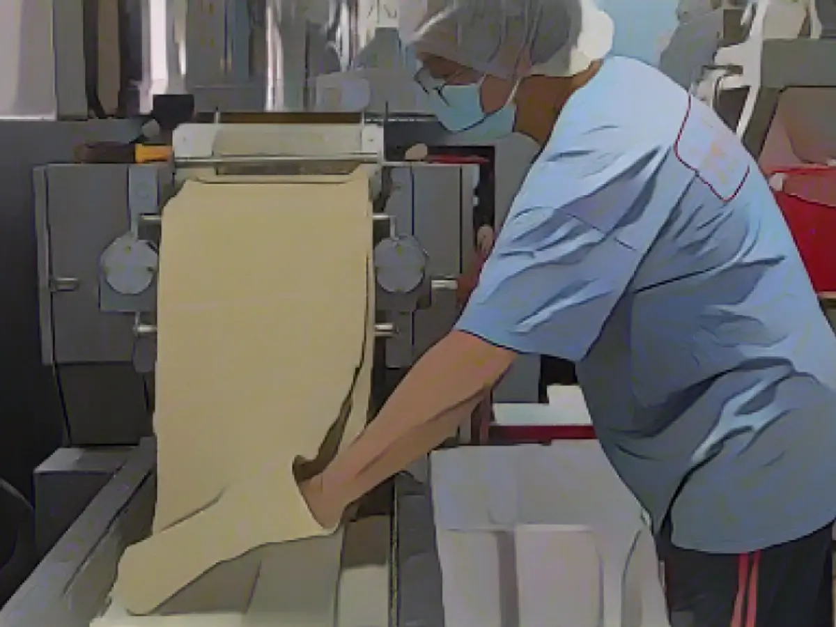 Un operaio prepara l'impasto prima di tagliare le tagliatelle. Il