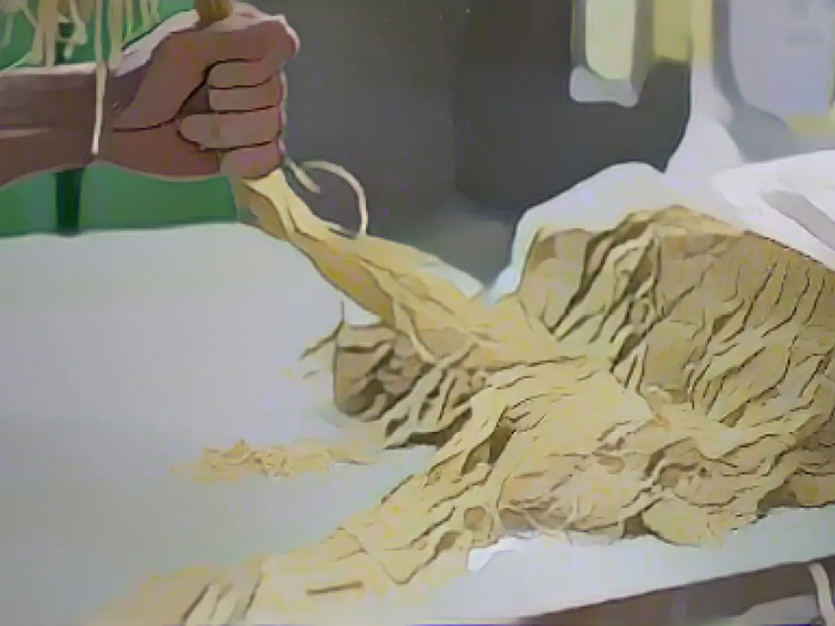 Un operaio prepara i noodles yi mein alla Aberdeen Yau Kee Noodles Factory. Gli spaghetti di grano all'uovo cantonesi, gommosi e spugnosi, vengono poi essiccati e fritti.