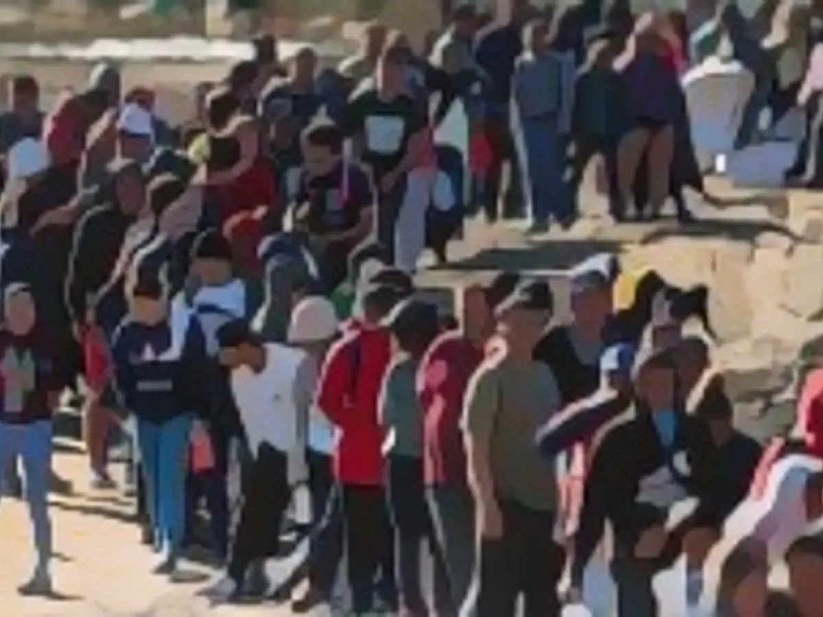 Более 1000 мигрантов ожидают оформления сотрудниками пограничного патруля США после пересечения реки Рио-Гранде в понедельник в Игл-Пасс, штат Техас. В последние недели американские власти перегружены из-за резкого увеличения числа иммигрантов, пересекающих южную границу США, до 12 000 человек в день.