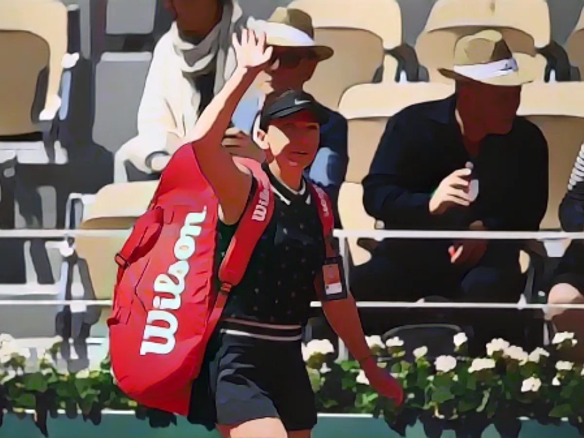 Simona Halep salută publicul după ce a pierdut în fața Amandei Anisimova la Roland Garros.