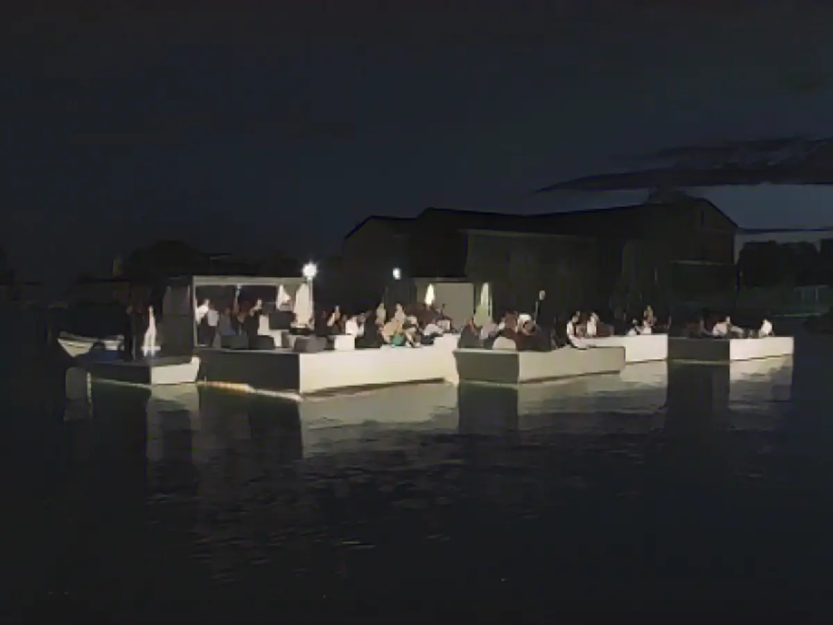 Konuklar tekneyle Kudu Adası'ndaki Nai Pi Lae lagününün sularına monte edilmiş modüler bir yapı olan yüzen sinemaya götürüldü ve kayaların içine yerleştirilmiş bir ekrana yansıtılan bir film izledi.