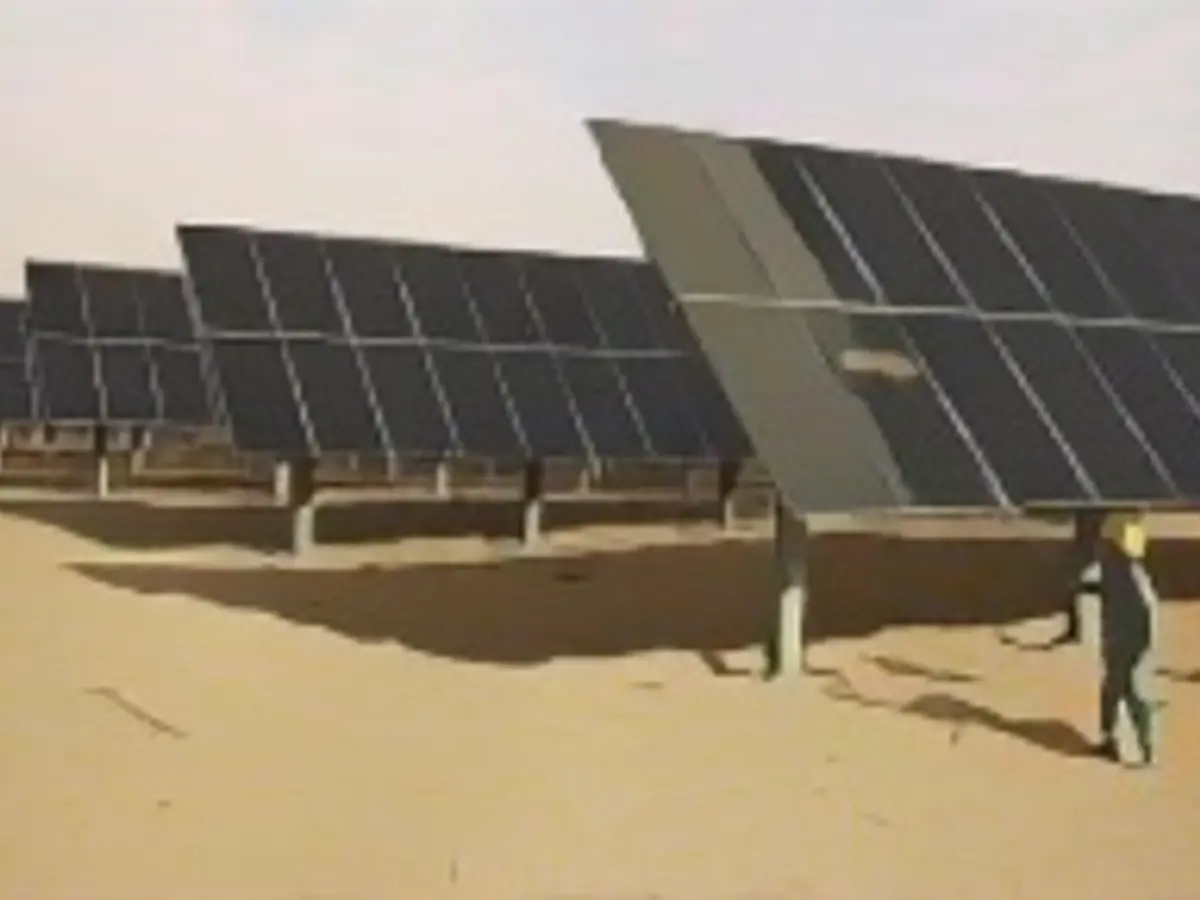 Un operaio pulisce i pannelli solari in una nuova base energetica in Cina.