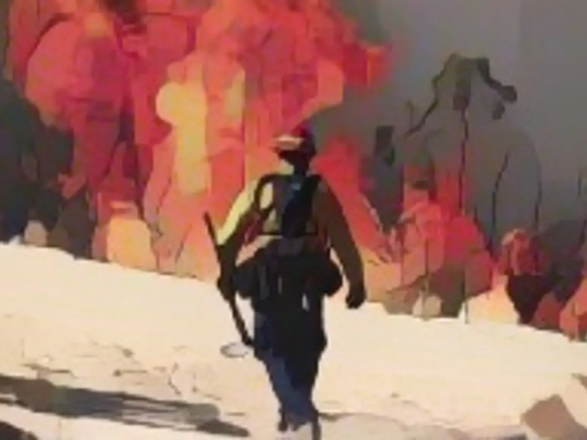 Um bombeiro caminha em direção às chamas enquanto o incêndio de Highland arde em Aguana, Califórnia, a 31 de outubro de 2023.