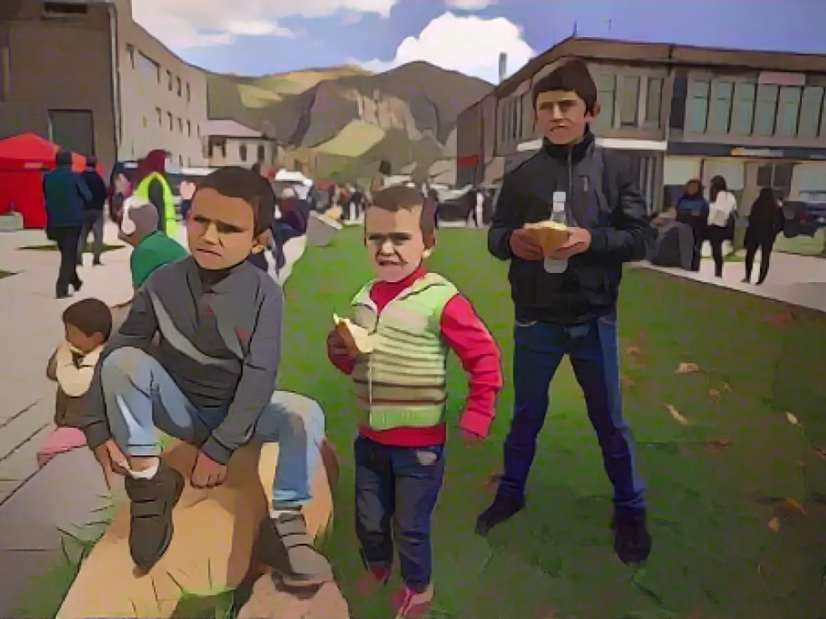 Des enfants arméniens attendent devant un centre d'enregistrement à Goris, en Arménie, tandis que leurs parents font la queue, le 27 septembre 2023.