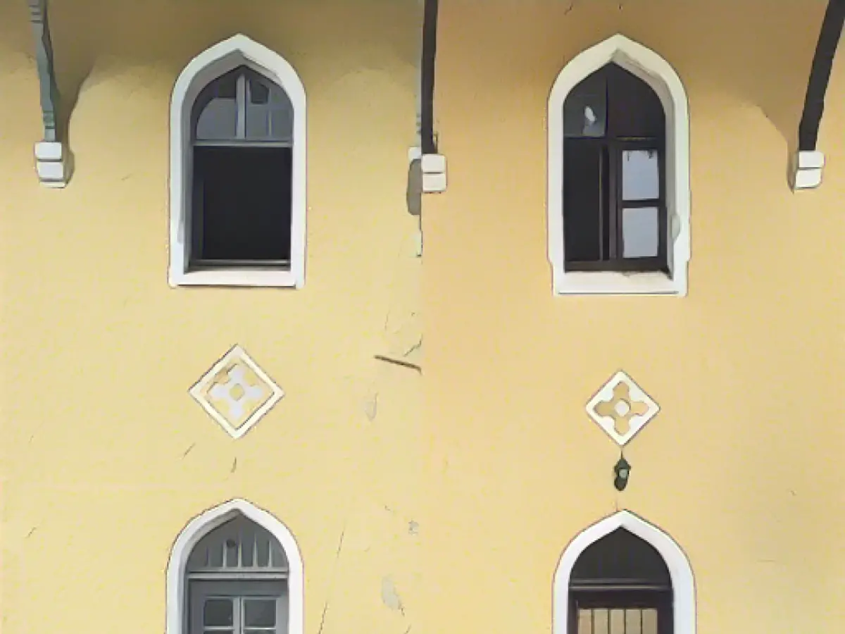 Bu yan yana fotoğraf, aynı planla inşa edilen ancak farklı süslemelere, pencerelere ve kapılara sahip iki istasyon olan Zeytinli (solda) ve Durak'ın (sağda) arka cephesini (rayların olmadığı taraf) göstermektedir.