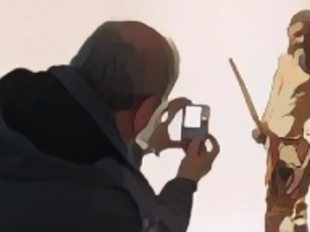 Мужчина фотографирует статую, изображающую ледяного человека по имени Оетци, обнаруженную в 1991 году в итальянском леднике Шналь Вэлли, в Археологическом музее Больцано 28 февраля 2011 года во время официальной презентации реконстукции. На основе трехмерных изображений скелета мумии, а также новейших криминалистических технологий голландские эксперты Альфонс и Адри Кеннис создали новую модель живого Оетци.   AFP PHOTO / Andrea Solero (Photo credit should read Andrea Solero/AFP via Getty Images)