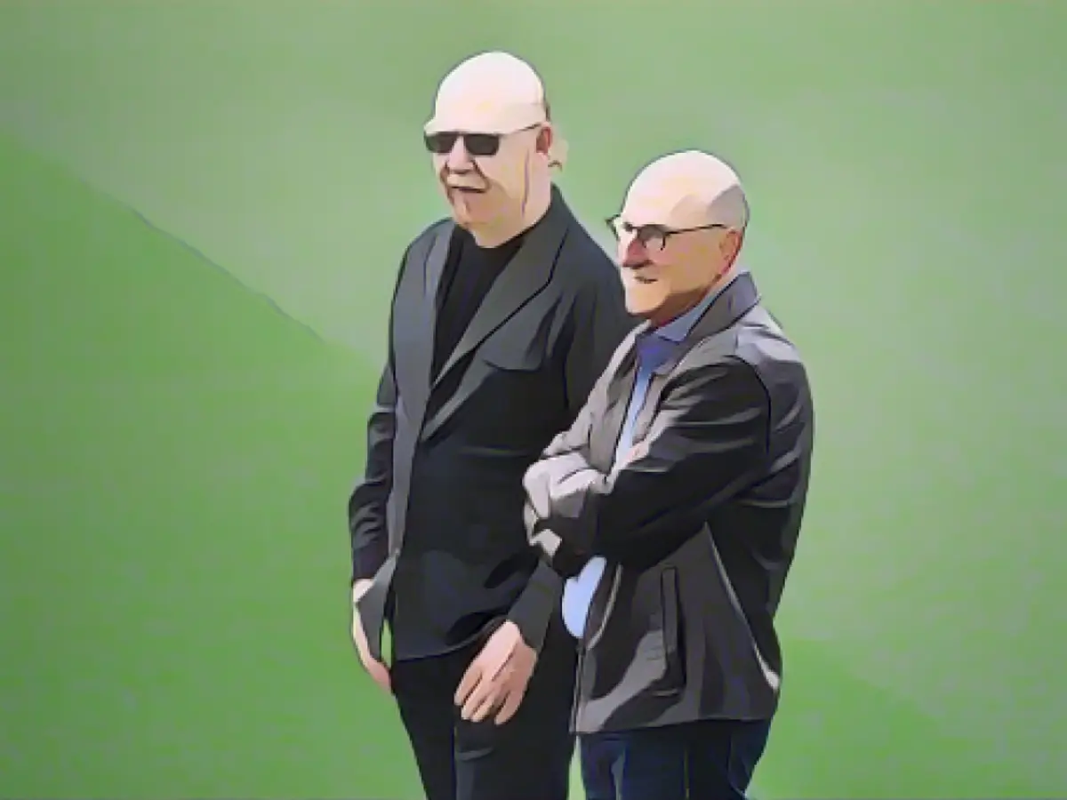 Joel e Avram Glazer assistem a uma sessão de treino.