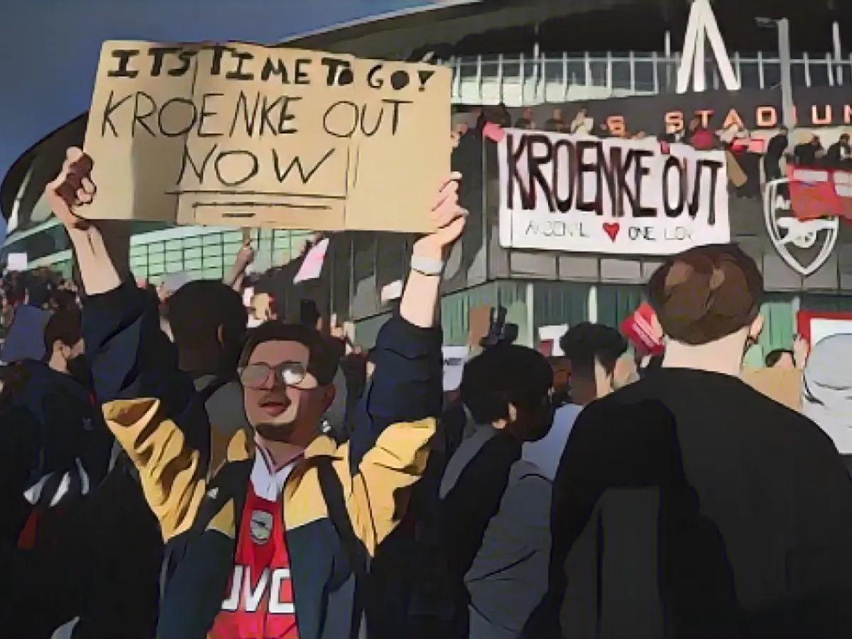 Adeptos do Arsenal seguram cartazes durante um protesto contra o proprietário do clube, Stan Kroenke.