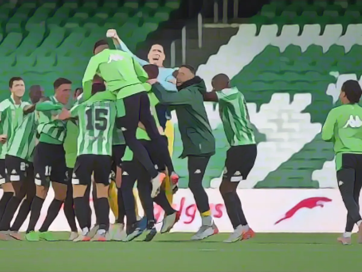 Os jogadores do Real Betis festejam num estádio vazio após o apito final de domingo.