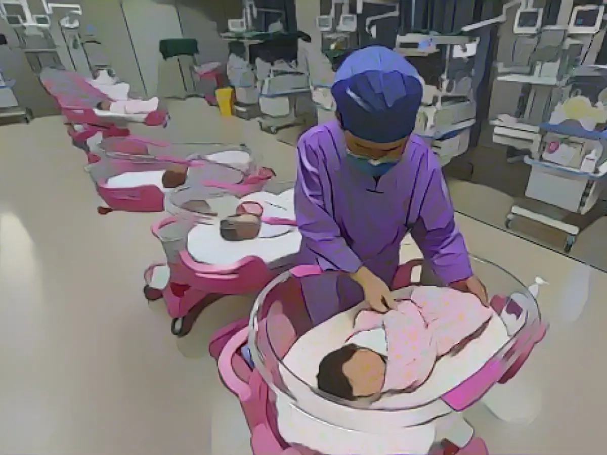 Медсестра ухаживает за новорожденным в женской и детской больнице в городе Фуян, провинция Аньхой, 8 августа 2022 года.