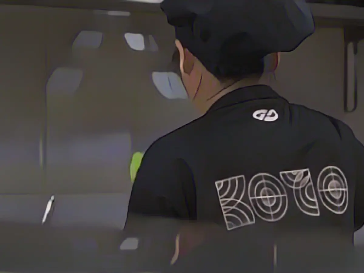 Uno studente di KOTO indossa una maglietta nera con il suo marchio mentre lavora.