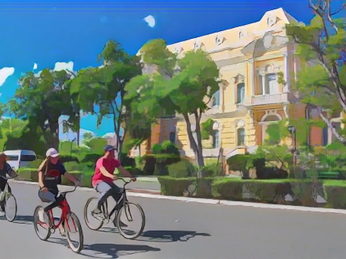 Yucatán'ın başkenti Mérida'daki Paseo de Montejo'da insanlar bisiklet rotası boyunca bisiklet sürüyor