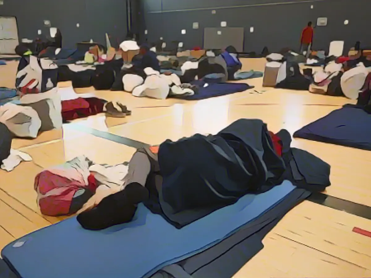 Мигрант лежит на спальном коврике во временном приюте в Денвере 13 января 2023 года.