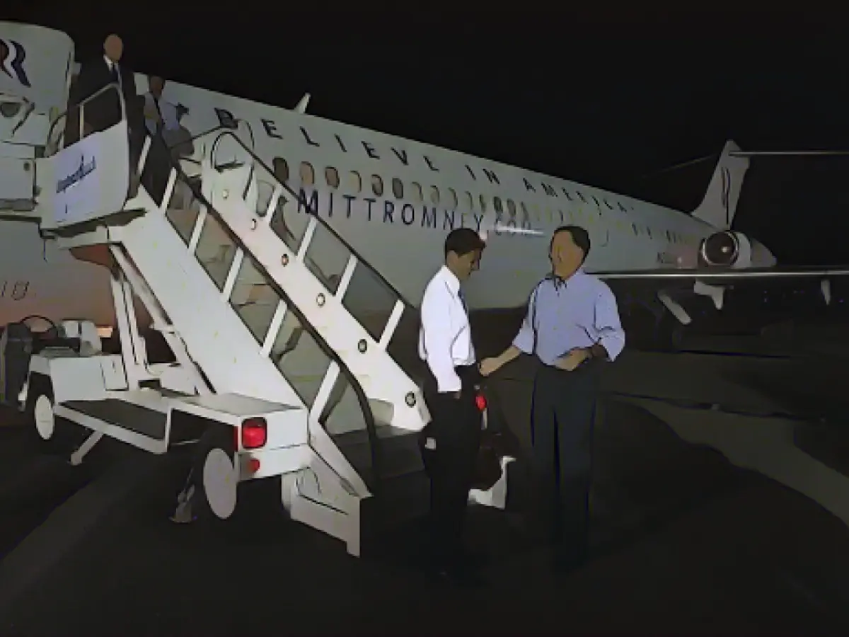 Mitt Romney (sağda) ve aday arkadaşı Paul Ryan 1970 model DC-9-32 uçağının dışında duruyor.