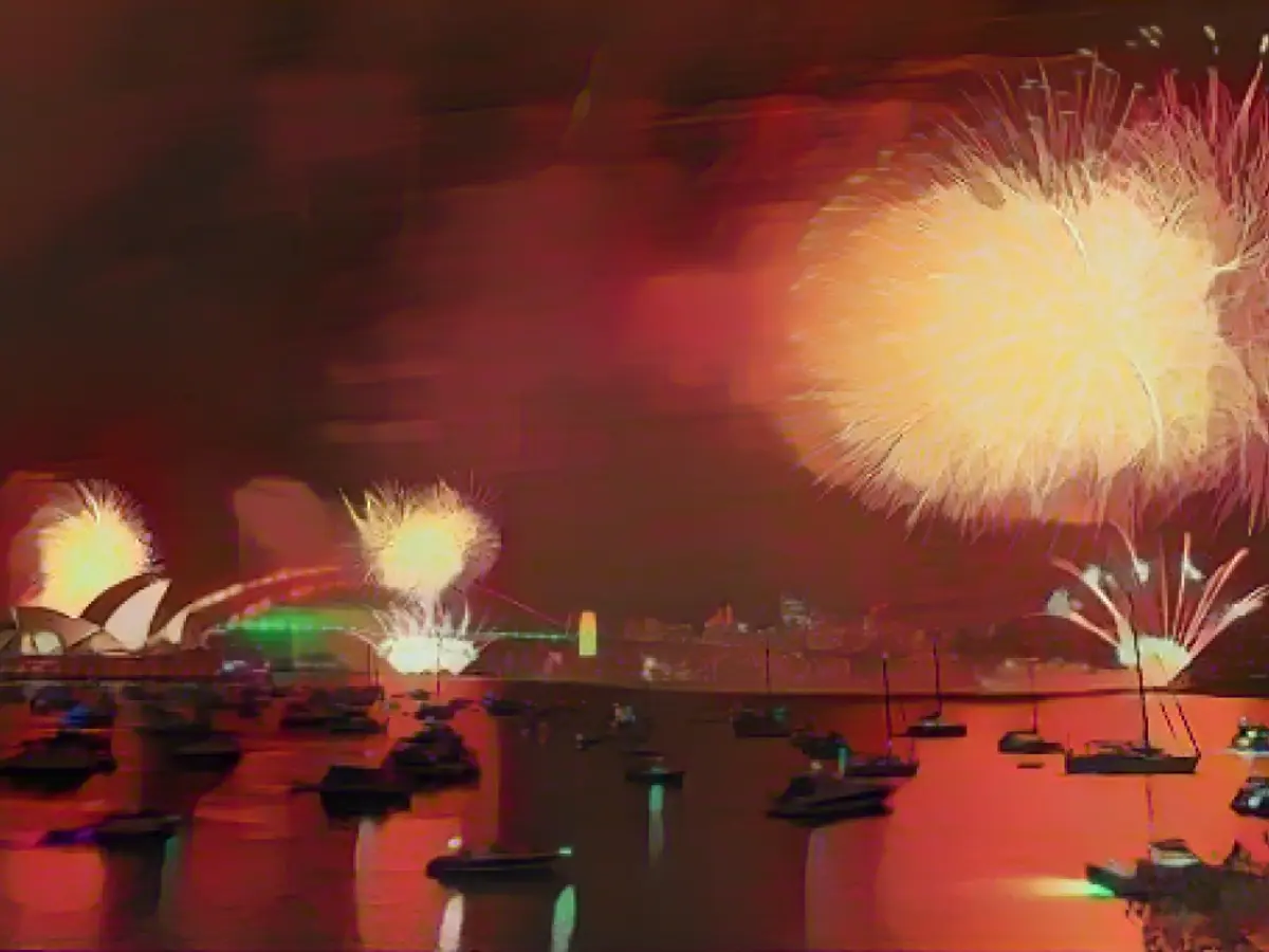 Фейерверк освещает небо над Сиднейским мостом через гавань во время празднования Нового года 31 декабря 2022 года в Сиднее, Австралия.