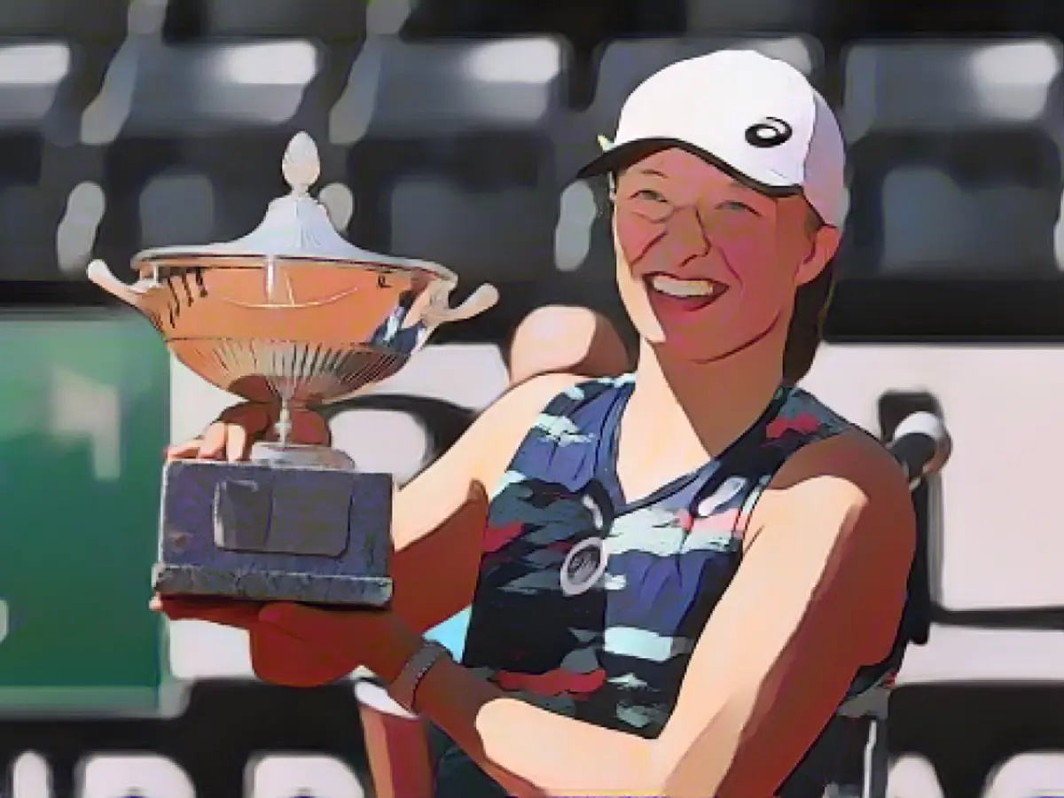 Swiatek posiert mit dem Siegerpokal, nachdem sie das Finale des WTA-Tennisturniers Women's Rome Open am 15. Mai 2022 gegen die Tunesierin Ons Jabeur gewonnen hat.