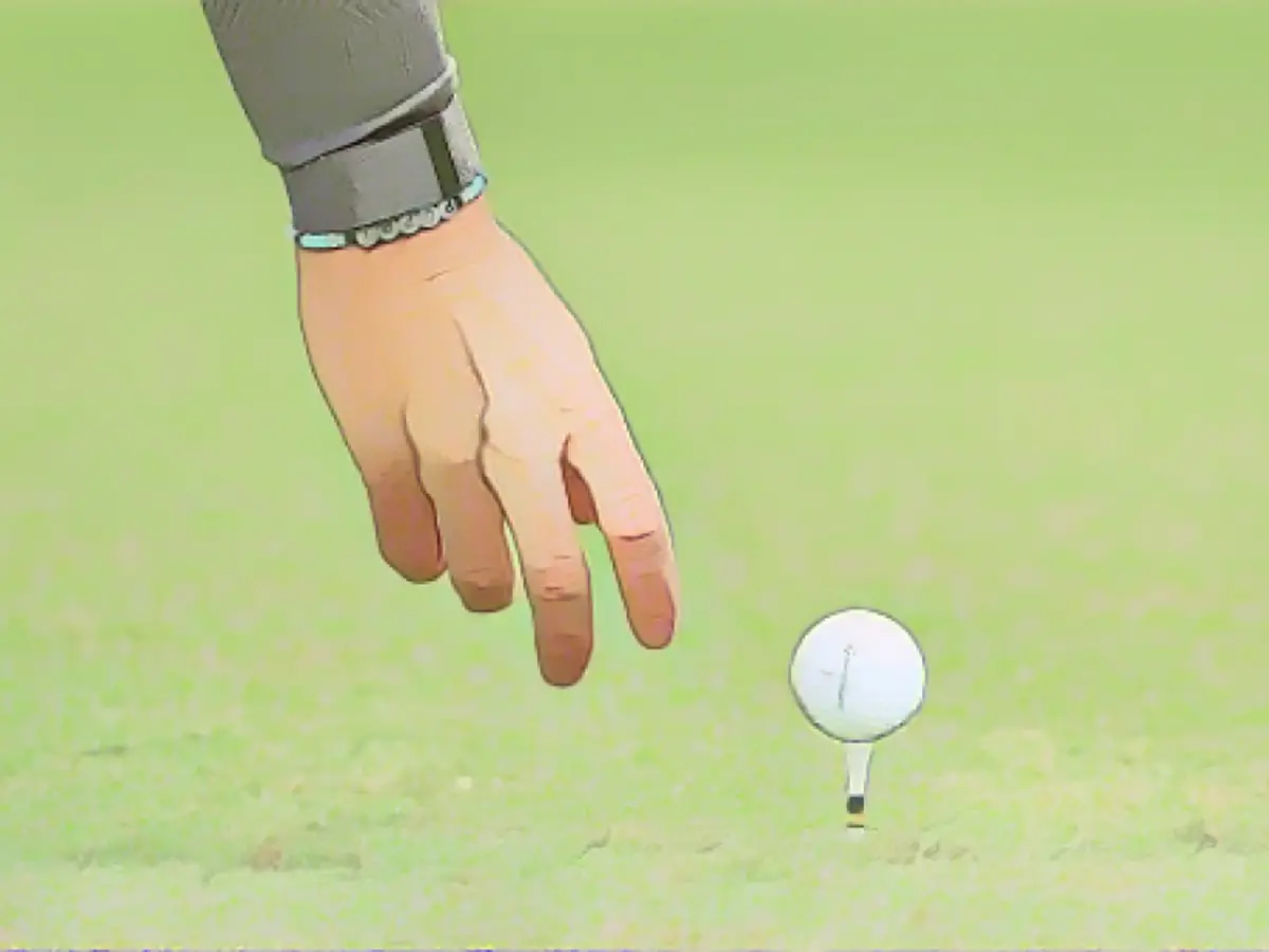 Rory McIlroy, üzerinde kızının adının yazılı olduğu bir bileklik takarak golf topunu dördüncü tee'ye yerleştiriyor.