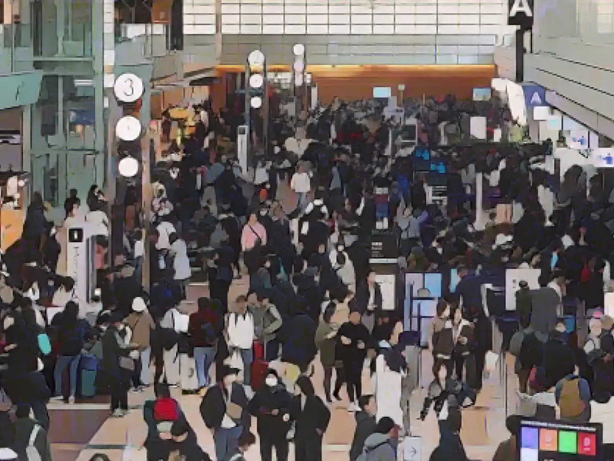 Путешественники толпятся в зоне регистрации в терминале 2 токийского аэропорта Ханеда 3 января 2024 года.