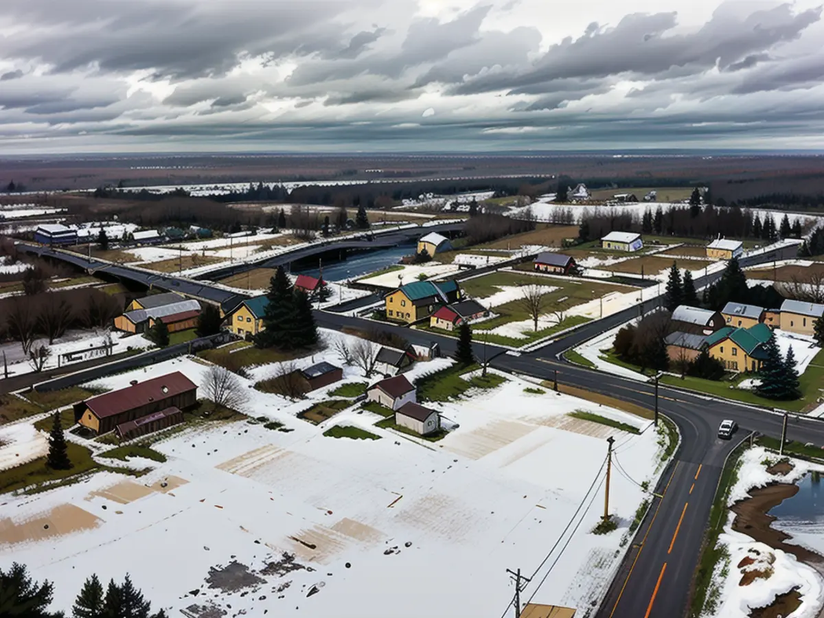 Autos fahren entlang der Hauptstraße und über den St. Regis River, links, durch das Reservat, das die Mohawks Akwesasne nennen, Dienstag, 15. März 2022. (AP Photo/Seth Wenig)