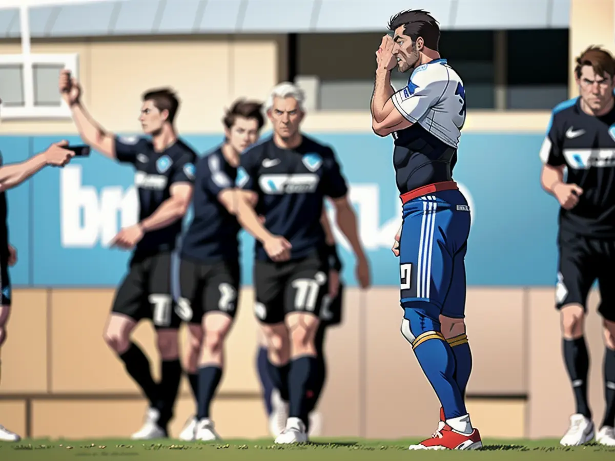 L'attaquant du HSV Jean-Luc Dompé enfouit son visage dans son maillot. Les supporters de Paderborn...