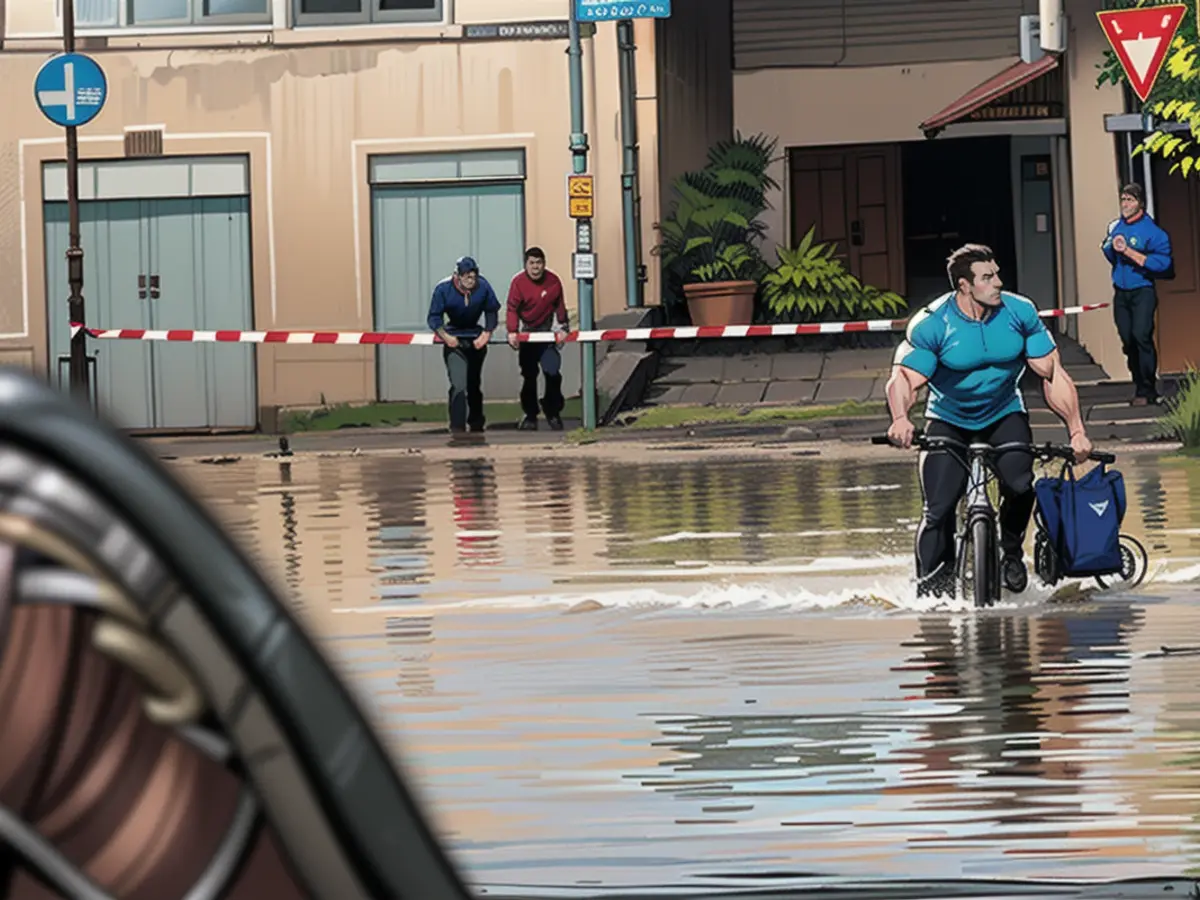 A cyclist gets his feet wet as he cycles through the flooded town