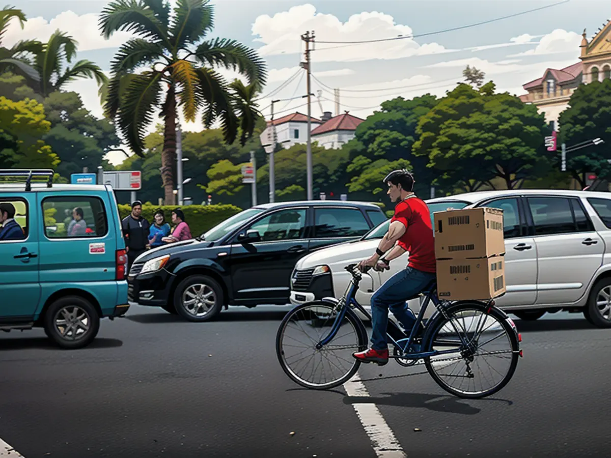 A delivery worker rides his bicycle through the traffic in Colaba, Mumbai, on April 17, 2024.