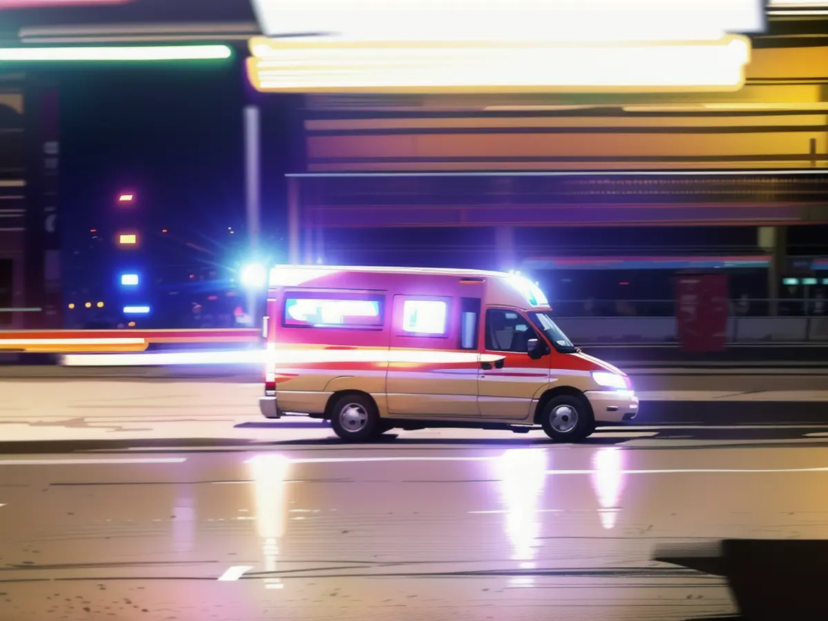 Une ambulance est sur la route avec des feux bleus clignotants.