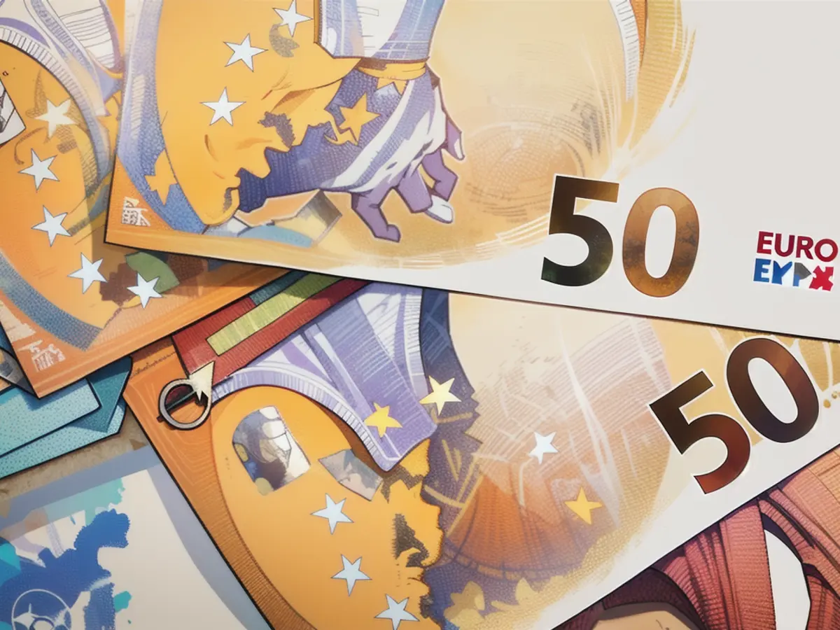 De nombreux billets de banque en euros sont posés sur une table.
