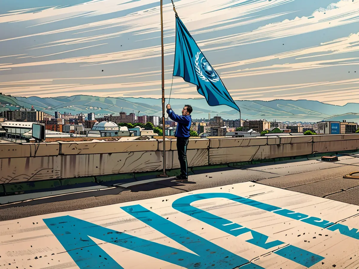 An employee at the United Nations Relief and Works Agency (UNRWA) lowers the UN flag on the roof of the organization's regional offices in the Lebanese capital Beirut on November 13, 2023.