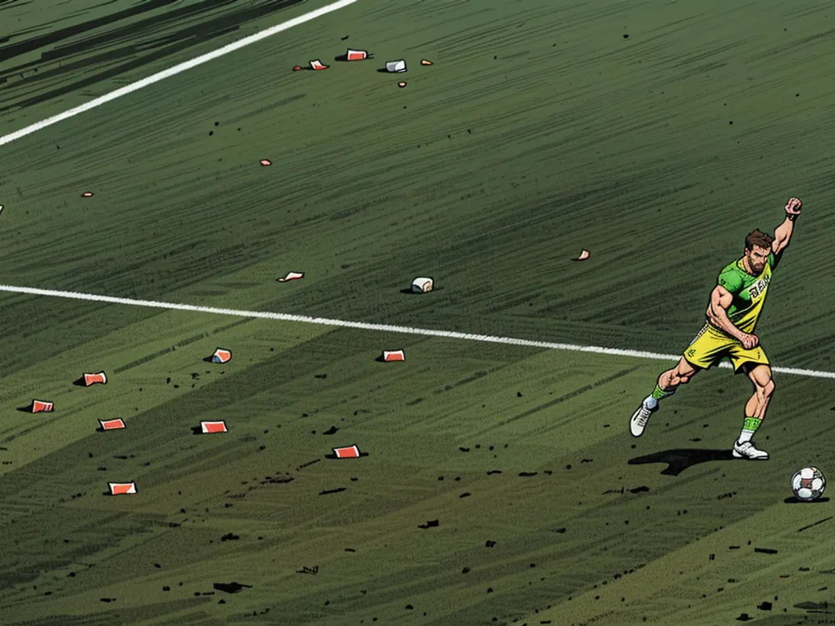 Il portiere della Slovenia Jan Oblak esegue un calcio di punizione durante la partita contro la Serbia a Euro 2024 con dei bicchieri di birra intorno a sé.