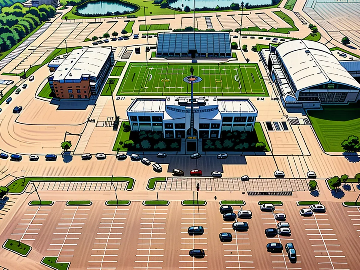  Una vista aérea de automóviles alineados alrededor de un estadio de fútbol.