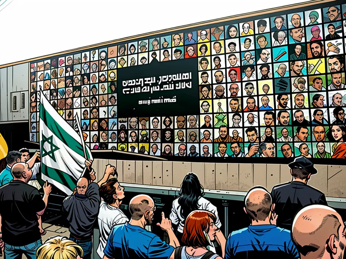 Persone si trovano vicino a un muro coperto da immagini di ostaggi israeliani detenuti dai militanti palestinesi di Hamas nella Striscia di Gaza dal 7 ottobre, durante una manifestazione contro il governo israeliano, nella città del nord di Israele di Karmiel il 25 luglio.