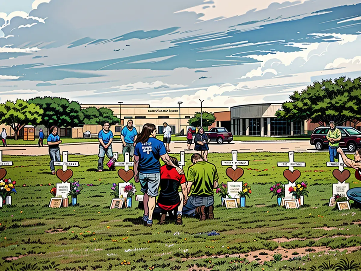 Pessoas visitam uma cruz para Christopher Stone em um memorial para as vítimas do tiroteio na Santa Fe High School em 21 de maio de 2018 em Santa Fe, Texas.