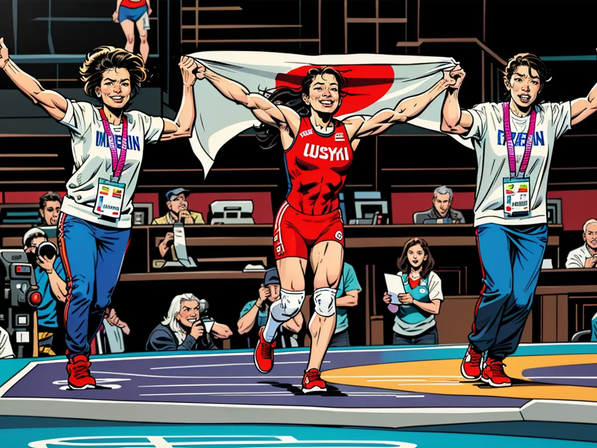 Yui Susaki celebrates with her coaches after winning gold in the Women's Freestyle 50kg final at the Tokyo 2020 Olympics.