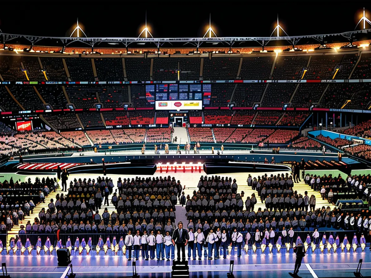 Crowds march through the Stade de France during the event's concluding spectacle.