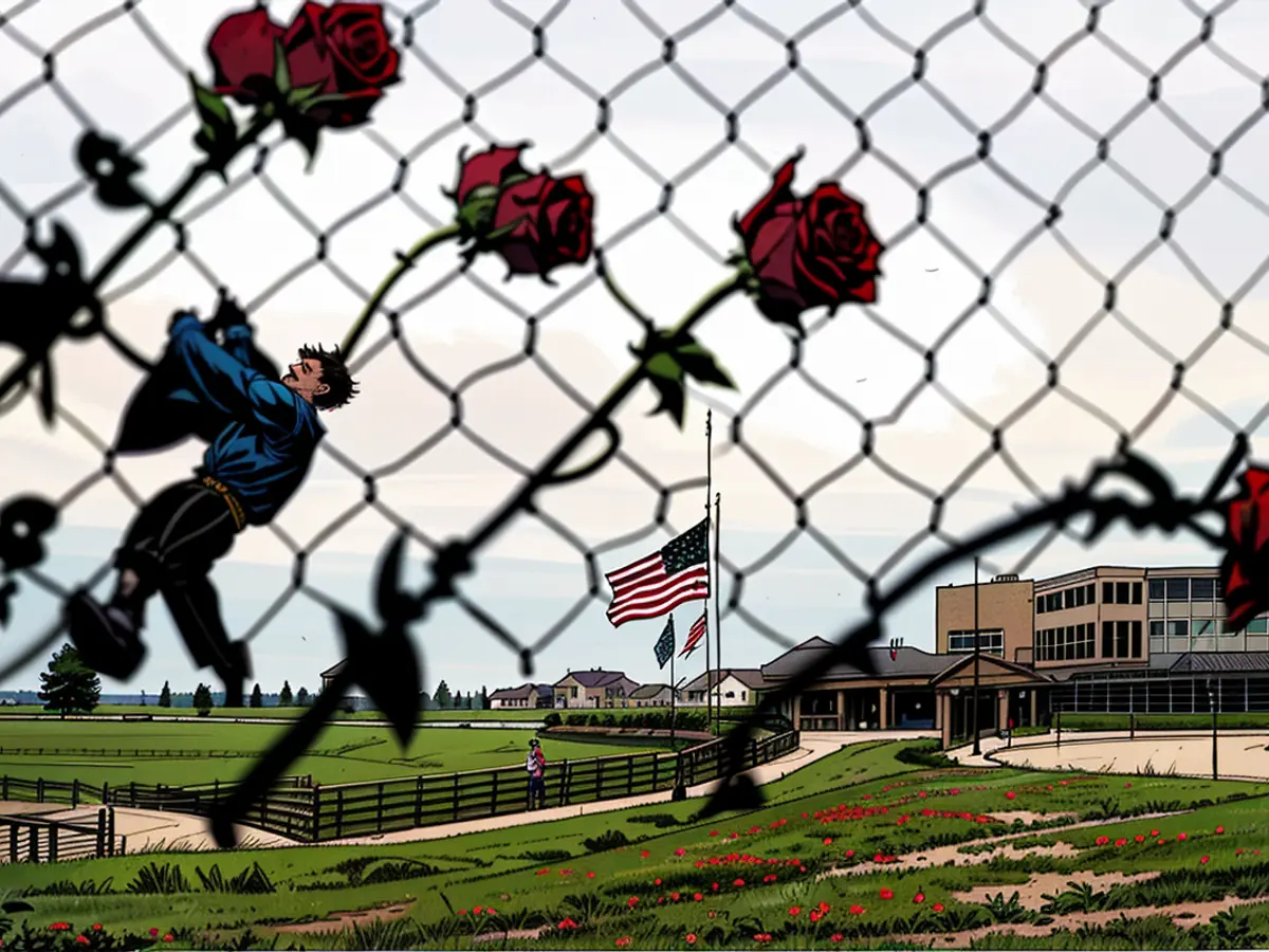 American flag is lowered and roses adorn a fence, showing respect to the victims of the previous week's shooting incident, which took place at Oxford High School in Michigan, on December 7, 2021.