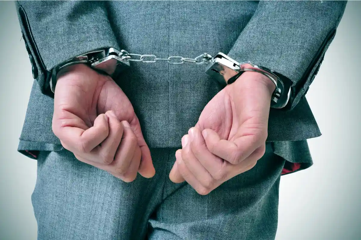 Мужчина в костюме с наручниками на спине Фото: nito/Shutterstock.com